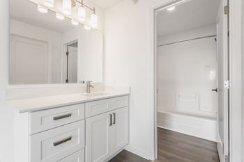 a white bathroom with a large mirror and a sink and a shower at Polo Run Apartments, Indiana, 46142